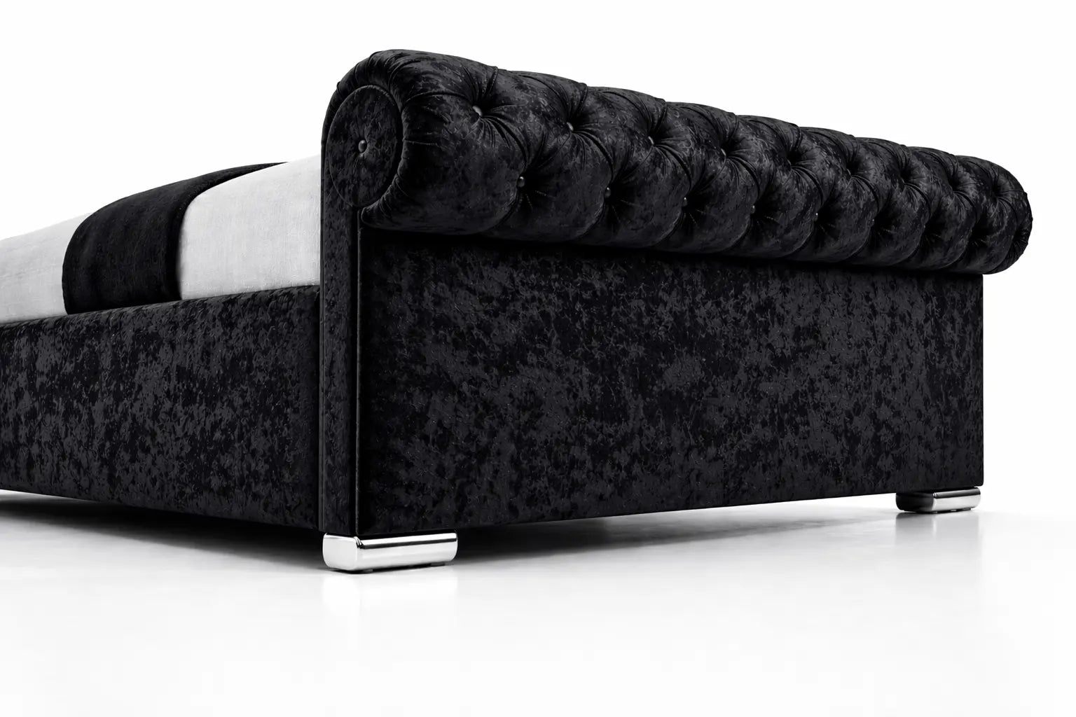 Black tufted bed with white mattress on a white background