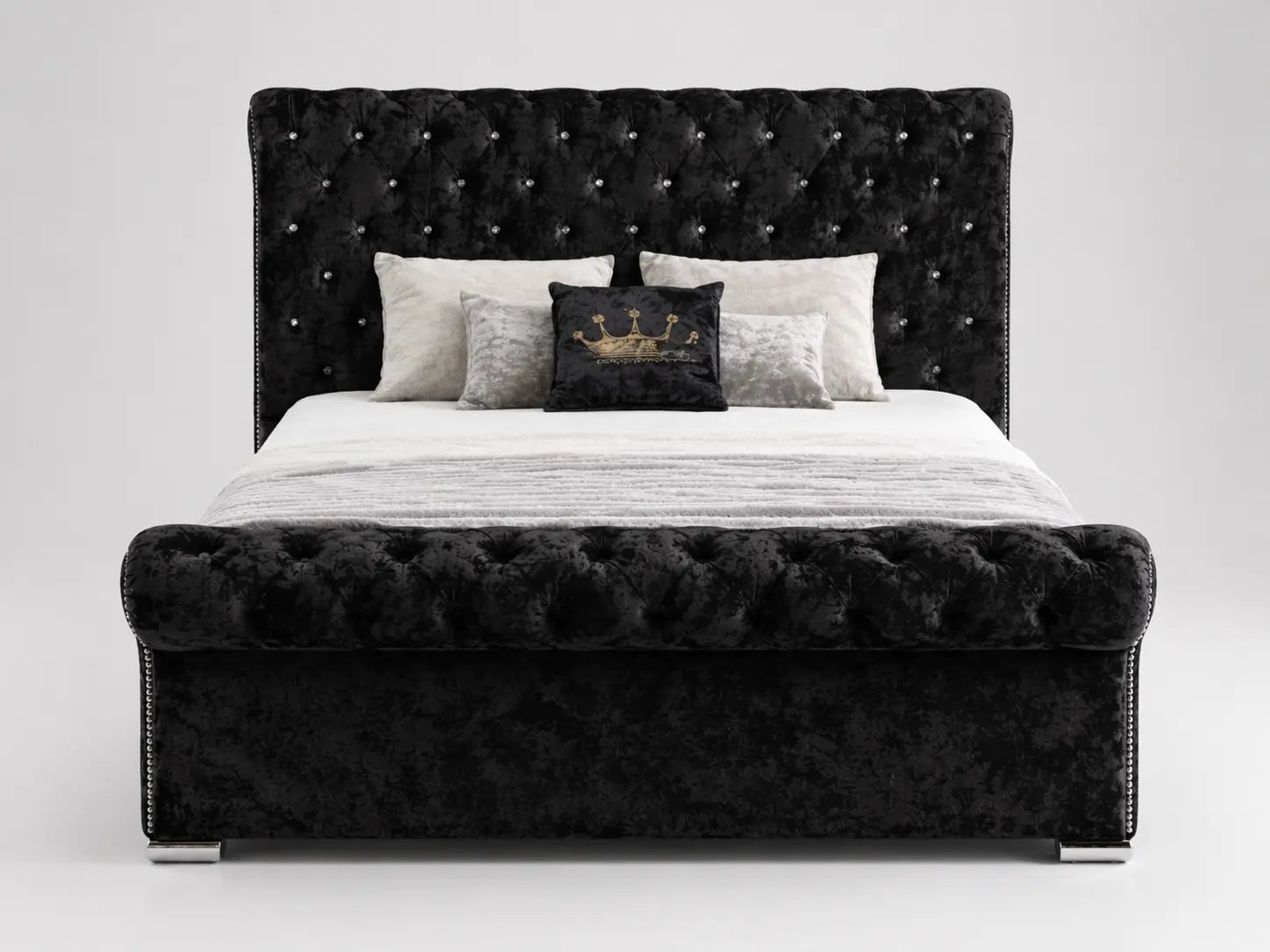 Black tufted bed with decorative pillows on a white background
