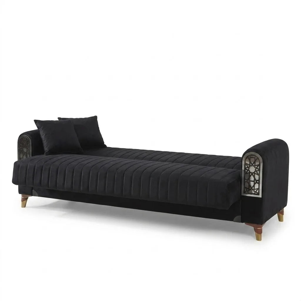 Black velvet sofa with decorative armrests on a white background