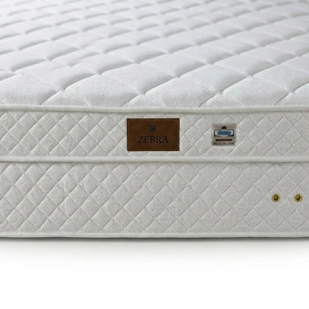 White mattress with quilted surface and Zebra branding on a white background