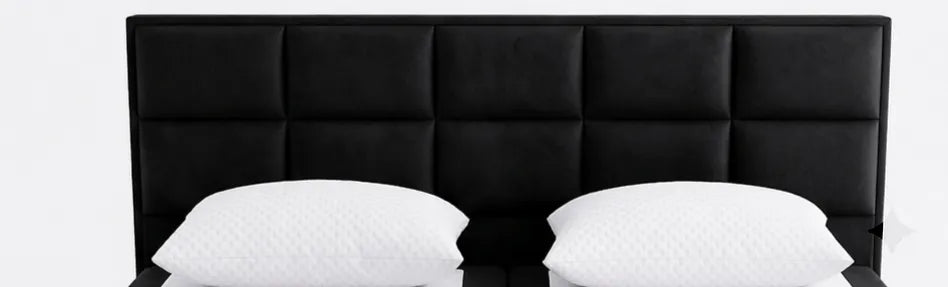Black upholstered headboard with two white pillows on a white background